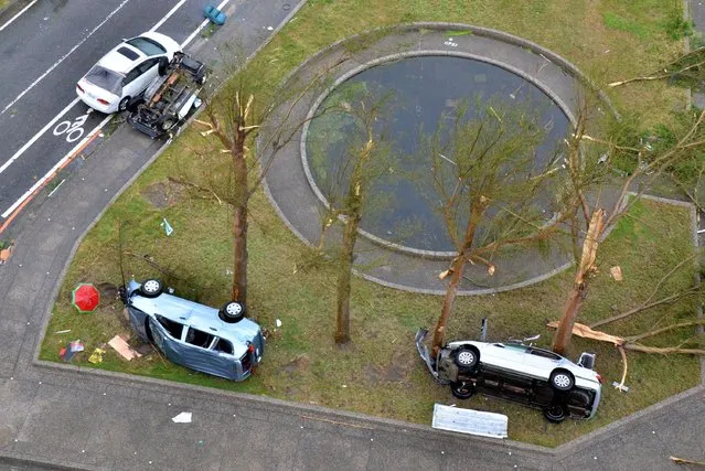 This overhead view shows three vehicles that were blown over by strong winds and reportedly carried some 100 metres down the road by strong winds, in the Taiwanese city of Taitung on July 8, 2016 after Super Typhoon Nepartak passed over the island. Super Typhoon Nepartak brought chaos to Taiwan on July 8, forcing more than 15,000 people to flee their homes as the strongest winds in over a century lashed part of the island. (Photo by AFP Photo/Stringer)