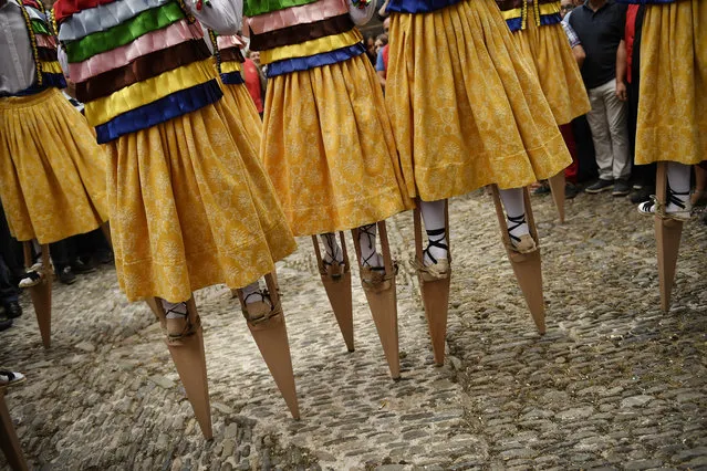 Dancers perform on stilts in honor of Saint Mary Magdalene in a street for the traditional “Danza de Los Zancos” (Los Zancos Dance), in the small town of Anguiano, northern Spain, Saturday, July 23, 2016. As an ancient tradition for more than 4th centuries, eight young people from the town balance on stilts down the old street, turning to the sound of folk music played on a pipe and drum. (Photo by Alvaro Barrientos/AP Photo)