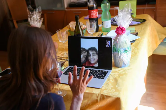 A woman talks with her sons on a video call during an Easter lunch, amid the coronavirus disease (COVID-19) outbreak, in Rome, Italy on April 12, 2020. (Photo by Alberto Lingria/Reuters)