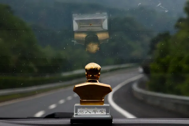 A bust of former Chinese leader Mao Zedong sits on the dashboard of a taxi as it drives through the mountains near Jinggangshan, Jiangxi province, China, September 14, 2017. (Photo by Thomas Peter/Reuters)