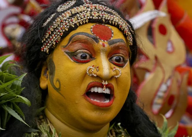 An Indian artist dressed as Hindu goddess Mahakali performs during a procession marking “Bonalu” festival in Hyderabad, India, Monday, August1, 2016. Bonalu is a month long Hindu folk festival of India's Telangana region dedicated to Kali, the Hindu goddess of destruction. (Photo by Mahesh Kumar A./AP Photo)