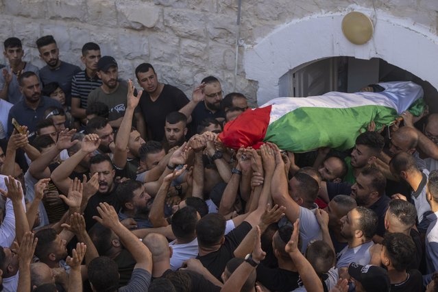 Mourners carry the body of Salah Sawafta, 58 during his funeral in the West Bank city of Tubas, Friday, August 19, 2022. Israeli forces shot and killed Sawafta during an arrest raid in the occupied West Bank on Friday, according to his brother, who said he was walking home when a bullet struck him in the head as Israeli forces clashed with Palestinian youths. (Photo by Nasser Nasser/AP Photo)