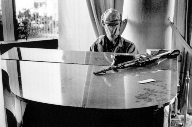 A masked Phalange gunman plays the piano, with his assault rifle momentarily set aside, in the downstairs musical bar of the Holiday Inn on November 3, 1975, in Beirut, Lebanon. The Holiday Inn is occupied by Phalangists battling leftist Muslim fighters in Beirut's “Hotel War”. The conflict took place during the broader Lebanese Civil War that lasted until 1990. (Photo by Lapousterle/AP Photo)