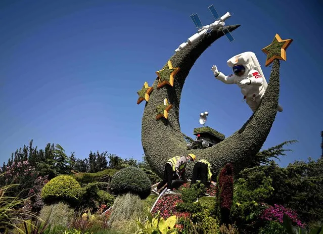 Workers installs a flower display depicting China's space program ahead of the China's National Day in Beijing on September 21, 2022. (Photo by Noel Celis/AFP Photo)