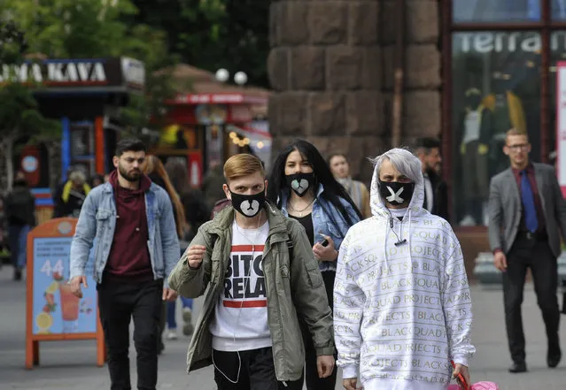 People wearing protective masks as a precaution walk down the street during the coronavirus crisis in Kiev, Ukraine on May 26, 2020. Ukrainian government by weakening quarantine restrictions, has allowed resuming work for the Kiev Metro in normal mode after a two-month ban introduced to slow the spread of coronavirus. (Photo by Sergei Chuzavkov/SOPA Images/LightRocket via Getty Images)