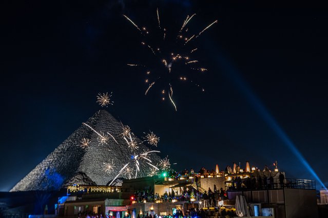 Fireworks explode above the Great Pyramids New Year's celebrations in Cairo on December 31, 2024. (Photo by Khaled Desouki/AFP Photo)
