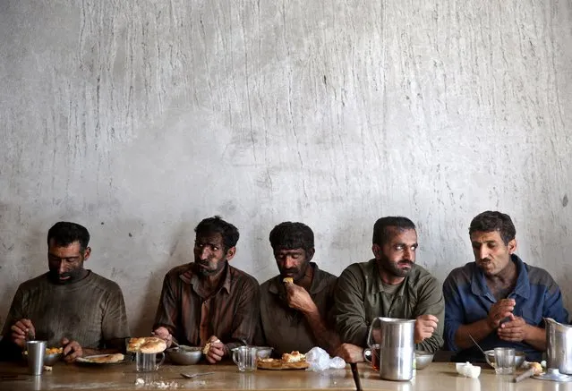 In this Tuesday, Aug. 19, 2014 photo, Iranian coal miners eat lunch at a mine near the city of Zirab 212 kilometers (132 miles) northeast of the capital Tehran, on a mountain in Mazandaran province, Iran. (Photo by Ebrahim Noroozi/AP Photo)