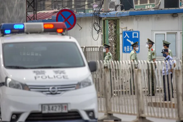 Paramilitary police stand guard on a street near the Xinfadi wholesale food market district in Beijing, Saturday, June 13, 2020. Beijing closed the city's largest wholesale food market Saturday after the discovery of seven cases of the new coronavirus in the previous two days. (Photo by Mark Schiefelbein/AP Photo)