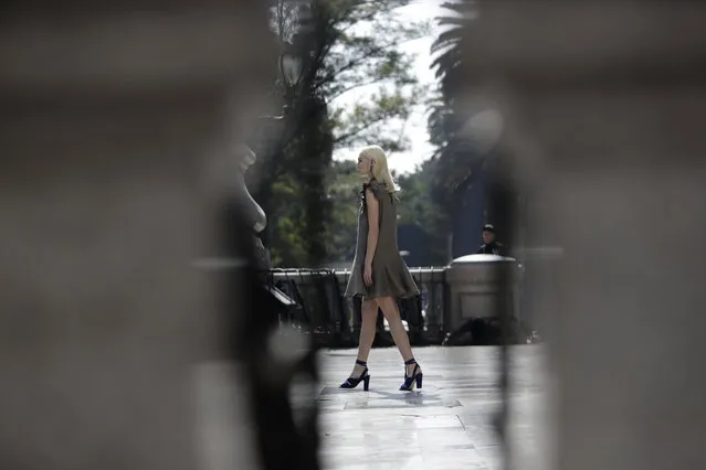 A model is seen between columns as she walks wearing a creation by Mexican fashion house Yakampot, during Mercedes-Benz Fashion Week runway show at the Angel of Independence monument, in Mexico City, Sunday, November 12, 2017. (Photo by Rebecca Blackwell/AP Photo)