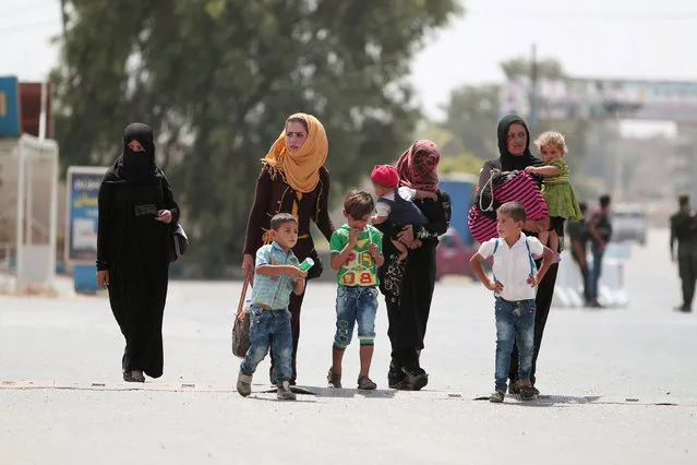 Women and children flee Hasaka after the Syrian government deployed warplanes to bomb the Kurdish-held areas in the city, on one of the exit points of Hasaka, Syria August 20, 2016. (Photo by Rodi Said/Reuters)
