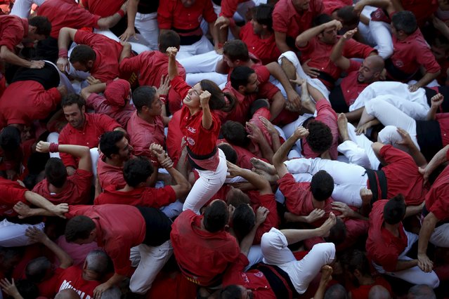 A member of the “Castellers Joves Xiquets de Valls” celebrates after forming a human tower or “castell” during the festival of the patron saint of Barcelona “The Virgin of Mercy” at Sant Jaume square in Barcelona, Spain, September 20, 2015. (Photo by Susana Vera/Reuters)