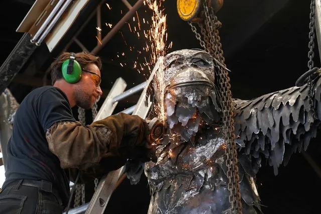 Sculptor Luke Perry in Cradley Heath, UK on Thursday October, 13, 2022 applies finishing touches with an angle grinder to his latest creation, a huge steel mother-and-baby orangutan statue to highlight the plight of the critically-endangered species. The structure, measuring around 40m, will be installed at Dudley Zoo, where two Bornean orangutans were born recently. (Photo by Jacob King/PA Images via Getty Images)
