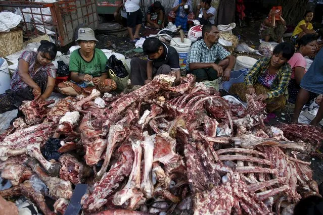 People remove meat from the bones of animals slaughtered for Eid al-Adha after they have been discarded at a garbage dump in Yangon, Myanmar, September 25, 2015. (Photo by Soe Zeya Tun/Reuters)