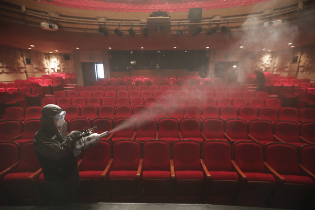 A worker wearing a protective gear sprays disinfectant as a precaution against a new coronavirus at a theater in Sejong Center in Seoul, South Korea, Tuesday, July 21, 2020. South Korea’s new virus cases have bounced back Tuesday, a day after it reported its smallest daily jump in local COVID-19 transmissions in two months. (Photo by Ahn Young-joon/AP Photo)