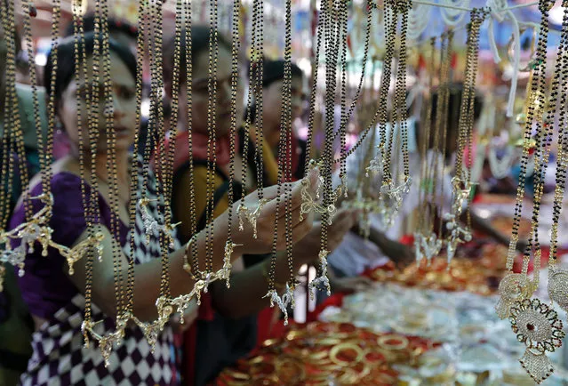 Women buy artificial jewellery at an open air market ahead of the Hindu festival of Diwali, in the western Indian city of Ahmedabad October 19, 2014. (Photo by Amit Dave/Reuters)