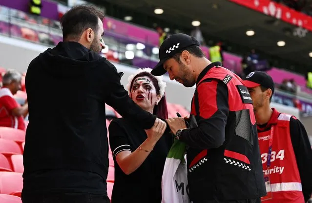 Members of security speak with two Iran supporters, as they take away a flag reading “Woman life freedom”, prior to the Qatar 2022 World Cup Group B football match between Wales and Iran at the Ahmad Bin Ali Stadium in Al-Rayyan, west of Doha on November 25, 2022. Iran has been rocked by more than seven weeks of nationwide protests over the death of 22-year-old Kurdish Iranian woman Masha Amini while in the custody of the Tehran morality police. (Photo by Dylan Martinez/Reuters)
