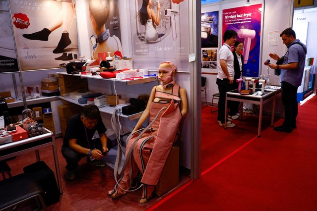 An employee rests next to a model with massage products at the China Import and Export Fair, commonly known as the Canton Fair, in Guangzhou, Guangdong province, China on April 15, 2025. (Photo by Tingshu Wang/Reuters)