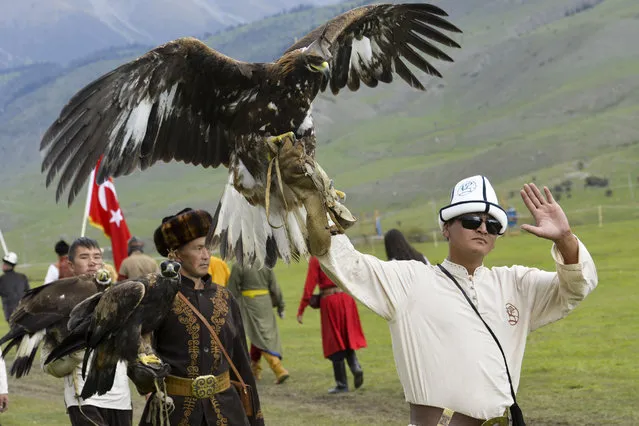 In this photo taken on Sunday, September 4, 2016, participants hold golden eagles for an eagle hunt during the second World Nomad Games at Issyk Kul lake in Cholpon-Ata, Kyrgyzstan. (Photo by Vladimir Voronin/AP Photo)