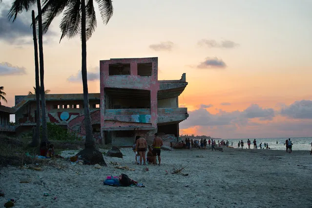 Cubans enjoy a warm April evening in the seaside beach town of Guanabo which is about 20 miles East of Havana. An abandoned low rise hotel sits on the beachfront which is experiencing sand loss and dune damage. The government has made the recovery of this beach a priority and some government and private homes are already being demolished. In some cases, new buildings will be built. (Photo by Sarah L. Voisin/The Washington Post)