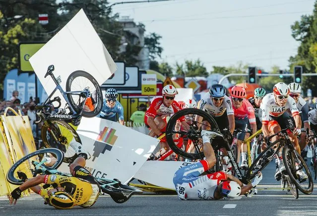 Dutch cyclist Fabio Jakobsen's bicycle (behind, L) flies through the air as he collides with compatriot Dylan Groenewegen (on the ground, L) during the opening stage of the Tour of Poland race in Katowice, southern Poland on August 5, 2020. The Dutch rider was fighting for his life on Wednesday after he was thrown into and over a barrier at 80km/h in a sickening conclusion to the opening stage of the Tour of Poland. (Photo by Szymon Gruchalski/Forum/AFP Photo)