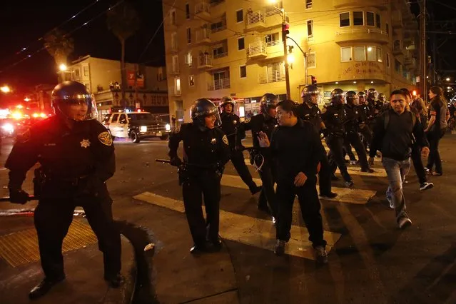 Police officers disperse a crowd in the Mission District, in San Francisco, California October 29, 2014. (Photo by Stephen Lam/Reuters)