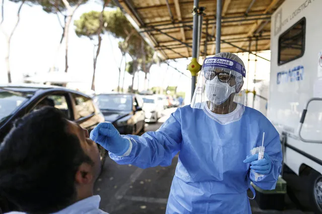 A  man undergoes testing for COVID-19 at Rome's San Giovanni Addolorata hospital, Friday, August 14, 2020. Italy is imposing mandatory testing on anyone arriving from Greece, Spain, Malta and Croatia as the number of new confirmed cases of coronavirus continues to nudge up with new cases recorded in every region of the country, often imported from abroad. (Photo by Cecilia Fabiano/LaPresse via AP Photo)