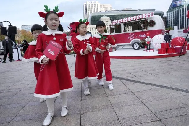 Children wearing Santa Claus outfits leave after attending a ceremony by the Salvation Army to prepare charity pots for a year-end fundraising campaign for the underprivileged in Seoul, South Korea, Monday, November 28, 2022. (Photo by Ahn Young-joon/AP Photo)