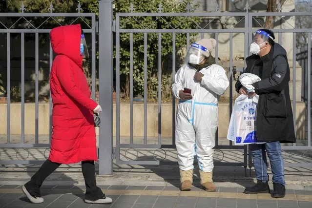 People wear protective gear outside a hospital in Beijing, Thursday, December 15, 2022. China said Wednesday that it would stop reporting asymptomatic COVID-19 cases since they've become impossible to track with mass testing no longer required, another step in the country's departure from some of the world's strictest antivirus policies. (Photo by Andy Wong/AP Photo)