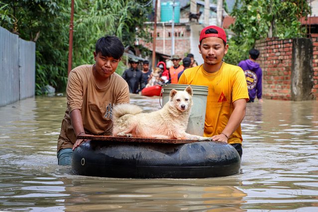 Men carry a dog on an inflated tube as they wade through floodwaters at Kongba in Imphal East on June 3, 2025. Flash floods and landslides after torrential monsoon rain over the last two days killed at least 30 people in India's northeast, officials said on June 1. (Photo by AFP Photo/Stringer)