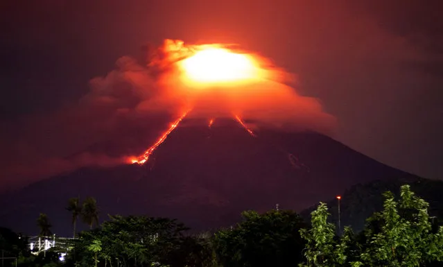 Lava cascades down the slopes of Mayon volcano as seen from Legazpi city, Albay province, around 340 kilometers (210 miles) southeast of Manila, Philippines, Monday, January 15, 2018. More than 9,000 people have evacuated the area around the Philippines' most active volcano as lava flowed down its crater Monday in a gentle eruption that scientists warned could turn explosive. (Photo by Earl Recamunda/AP Photo)