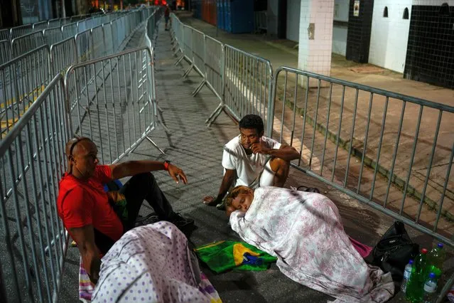 Soccer fans sleep outside the Vila Belmiro stadium waiting for the doors to open for the wake of the late Brazilian soccer star Pele, in Santos, Brazil Monday, January 2, 2023. (Photo by Matias Delacroix/AP Photo)