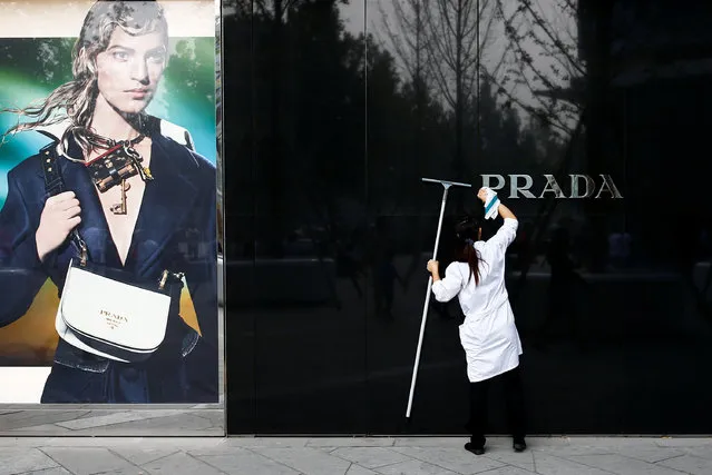 A woman cleans the brand logo at a Prada fashion boutique in Beijing, China, September 16, 2016. (Photo by Thomas Peter/Reuters)