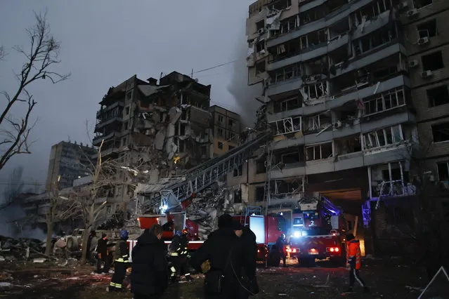 Emergency workers clear the rubble after a Russian rocket hit a multistory building leaving many people under debris in Dnipro, Ukraine, Saturday, January 14, 2023. (Photo by Roman Chop/AP Photo)