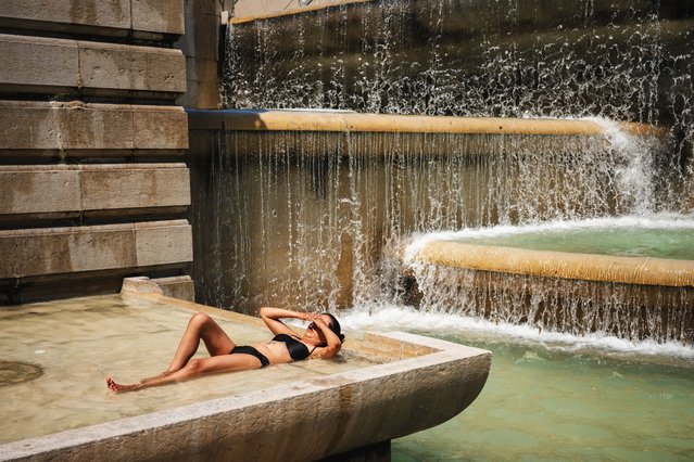 A woman in a swimsuit cools off in the Trocadero Fountain, in front of the Eiffel Tower in Paris, on July 2, 2025, as a heatwave hits France. France registered its second-warmest June since records began in 1900, said the country's ministry for ecological transition on July 2, 2025, as Europe swelters under an early summer heatwave. (Photo by Dimitar Dilkoff/AFP pHOTO)