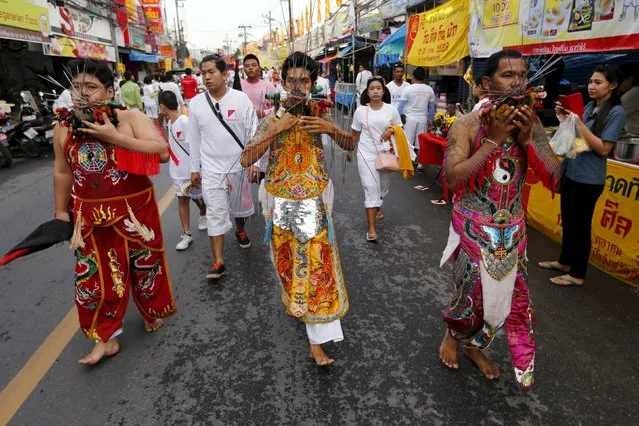 Devotees of the Chinese Samkong Shrine walk with spikes pierced through their faces and bodies during a procession celebrating the annual vegetarian festival in Phuket, Thailand, October 16, 2015. (Photo by Jorge Silva/Reuters)