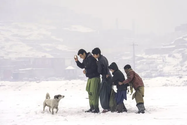 Afghan boys enjoy their time playing in a snowy day on the outskirts of Kabul, Afghanistan, Wednesday, January 11, 2023. (Photo by Ebrahim Noroozi/AP Photo)