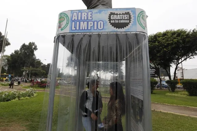 People breathe fresh air from a giant air purifier, which its inventor calls a “super tree”, in Lima's district of Jesus Maria November 24, 2014. (Photo by Mariana Bazo/Reuters)