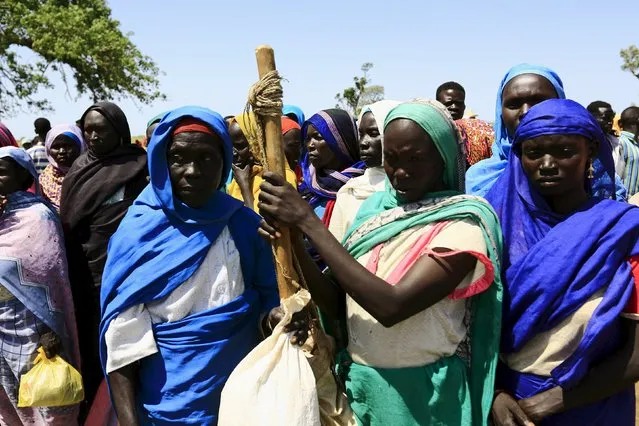 Displaced people gather to receive food provided by the United Nations' World Food Programme (WFP) during a visit by a European Union delegation, at an IDP camp in Azaza, east of Ad Damazin, capital of Blue Nile state, October 21, 2015. (Photo by Mohamed Nureldin Abdallah/Reuters)