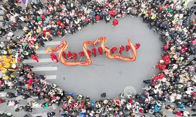 An aerial view of people performing the dragon dance in Qianyuan Town of Deqing County in Huzhou, Zhejiang Province, China, 04 February 2023 (issued 05 February 2023). The Lantern Festival, the 15th day of the first month of the Chinese lunar calendar, falls on 05 February this year. Various folk cultural activities were held across the country to welcome the upcoming festival. (Photo by Xie Shangguo/EPA/Xinhua News Agency)