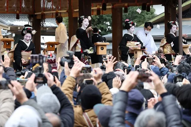 Traditional “maikos” (top-facing), or apprentice “geishas”, in traditional dress distribute small packets of beans to drive away evil spirits and welcome in the coming of spring, during the annual Setsubun Festival at Yasaka Shrine in Kyoto on February 2, 2023. (Photo by JIJI Press/AFP Photo)