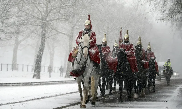 Members of the Household Cavalry return to their barracks as snow falls in London, Wednesday, February 28, 2018. Britain, which is buffered by the Atlantic Ocean and tends to have temperate winters, saw heavy snow in some areas that disrupted road, rail and air travel and forced hundreds of schools to close. (Photo by Alastair Grant/AP Photo)