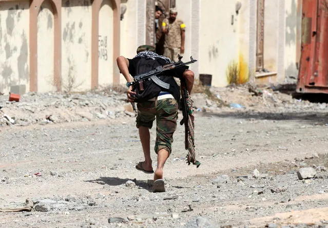 A fighter from Libyan forces allied with the U.N.-backed government runs for cover during a battle with Islamic State militants in neighbourhood Number Three in Sirte, Libya October 3, 2016. (Photo by Hani Amara/Reuters)