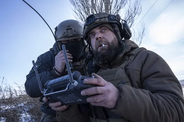 A Ukrainian serviceman aka Zakhar, right and commander of a unit aka Kurt, look on a screen of a drone remote control during fighting, at the frontline in Donetsk region, Ukraine, Monday, February 13, 2023. (Photo by Evgeniy Maloletka/AP Photo)