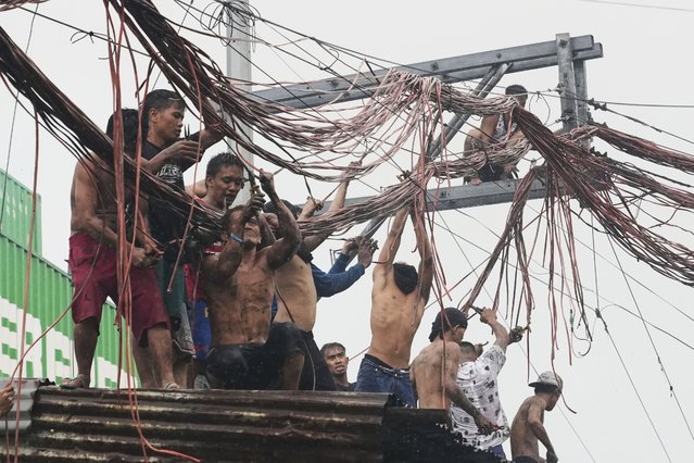 Residents salvage electrical wire for selling, after a massive fire broke out in the residential area of Manila, Philippines, August 6, 2025. (Photo by Aaron Favila/AP Photo)