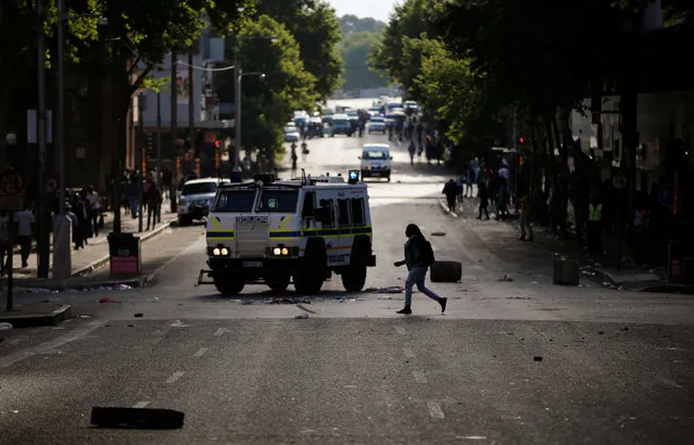 A pedestrian crosses a street during protests by students demanding free education on Monday outside the University of the Witwatersrand at Braamfontein, in Johannesburg, South Africa, October 10,2016. (Photo by Siphiwe Sibeko/Reuters)