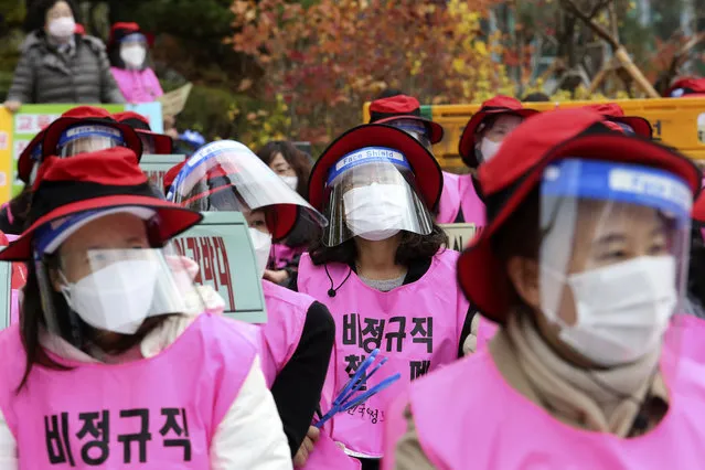Schoolchild care workers at elementary schools wearing face masks and shields to help protect against the spread of the coronavirus attend a rally to demand better working conditions in Seoul, South Korea, Friday, November 6, 2020. (Photo by Ahn Young-joon/AP Photo)