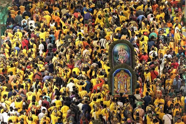 Hindu devotees carry decorated canopies called “kavadi”, while climbing the 272 steps to Sri Subramaniar Swamy Temple during Thaipusam celebrations at Batu Caves, in Kuala Lumpur, Malaysia, Sunday, February 5, 2023. Thaipusam, which is celebrated in honor of Hindu god Lord Murugan, is an annual procession by Hindu devotees seeking blessings, fulfilling vows and offering thanks. (Photo by Vincent Thian/AP Photo)