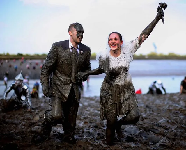 A couple dressed as a bride and groom take part in the Maldon Mud Race in Maldon, Essex, on May 5, 2013. (Photo by Dan Kitwood/Getty Images)