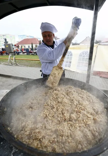 An employee makes food for free distribution during the regional harvest festival in the town of Dyatlovo, Belarus, November 13, 2015. (Photo by Vasily Fedosenko/Reuters)