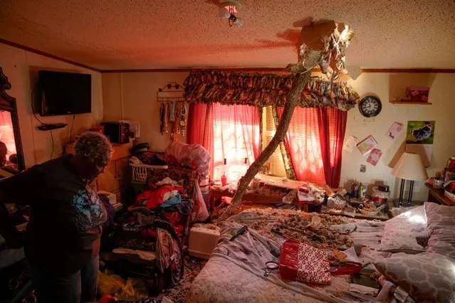 A tree branch is seen impaled through the ceiling as Ester Johnson-El, 62, inspects the wreckage of her bedroom where she rode out the storm with her nephew, grandson, and her grandson's mother, in the aftermath of a tornado, after a monster storm system tore through the South and Midwest on Friday, in Wynne, Arkansas, U.S. April 1, 2023. (Photo by Cheney Orr/Reuters)
